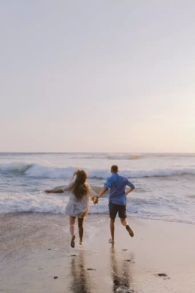 ADHD and Toxic Relationship; what you need to know. Image of couple running into the ocean at the beach on overcast day holding hands. 