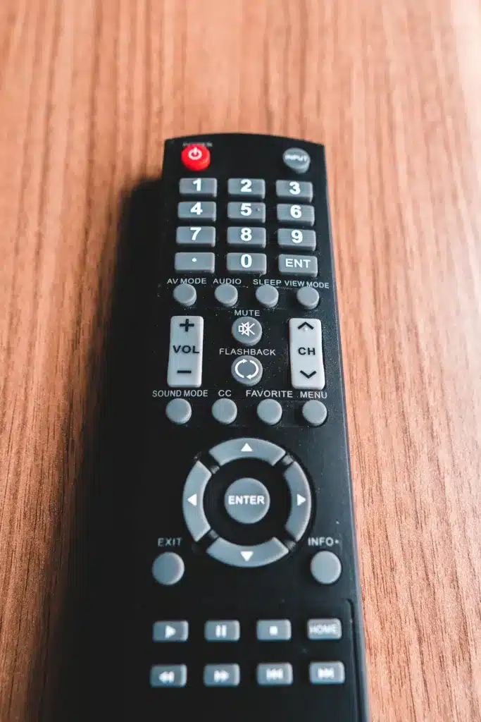 Remote control laying on a wooden surface. 
  